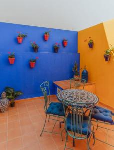 a room with a table and chairs and a blue wall at Picasso - Spacious Apartment in Old Town Nerja in Nerja