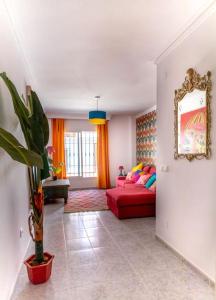 a living room with a red couch in a room at Picasso - Spacious Apartment in Old Town Nerja in Nerja