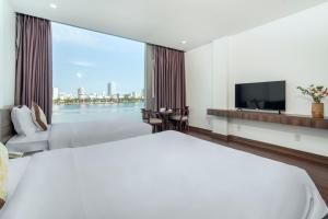 a hotel room with a large bed and a large window at Hoang Linh Riverside Hotel Danang in Da Nang