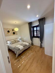 um quarto com uma cama grande e piso em madeira em House Varoš em Zadar
