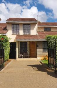 a house with a brown door and a driveway at MAMU'S RESIDENCE near JKIA in Nairobi