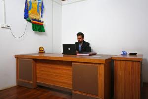 un hombre sentado en un escritorio con un portátil en Nubra Escapes, en Hundar