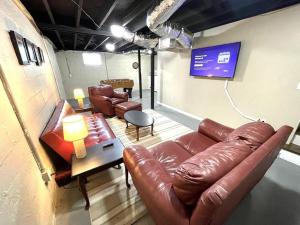a living room with a leather couch and chairs at Stay @ The Birchwood/Remodeled & 15 min to DT in Birmingham