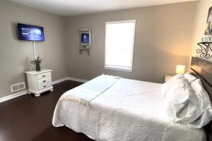 a bedroom with a white bed and a window at Stay @ The Birchwood/Remodeled & 15 min to DT in Birmingham