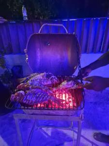 Eine Person kocht Essen auf einem Grill in der Unterkunft MAMELLO Beach Club Maldives in Feridhoo