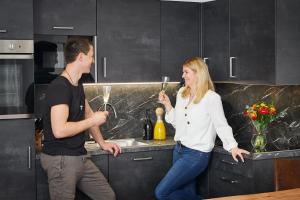 Un uomo e una donna in piedi in una cucina di Apartment Lina & Lejs a Gröbming
