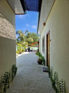 un couloir d'un bâtiment avec une cour ornée de plantes dans l'établissement MAMELLO Beach Club Maldives, à Feridhoo