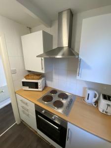 a kitchen with a stove and a microwave at Farina No1, Sea view studio sleeping 2 guests in Bridlington