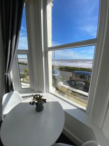 a white table and a window with a view of a car at Farina No1, Sea view studio sleeping 2 guests in Bridlington +1 photo