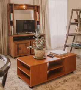 - un salon avec une table basse en bois et une télévision dans l'établissement De Hoop Cottage + Netflix, à Kempton Park