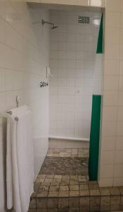 La salle de bains est pourvue d'une douche verte et blanche avec des serviettes. dans l'établissement De Hoop Cottage + Netflix, à Kempton Park