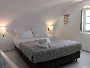 ein Schlafzimmer mit einem Bett mit zwei Handtüchern darauf in der Unterkunft ENDLESS SUMMER in Oia + 2 Fotos