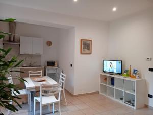 une cuisine avec une table et une télévision sur un comptoir dans l'établissement Casa Adelina - Appartamento Pallanza centro, à Verbania