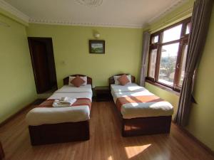 3 camas en una habitación con paredes verdes en Cloud 9 Garden en Katmandú