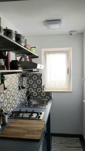 a kitchen with a stove and a window at Arte in piazza Agrigento centro in Agrigento