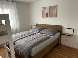 Schlafzimmer mit einem Bett mit einem Kopfteil aus Holz in der Unterkunft Casa Estella in Rust