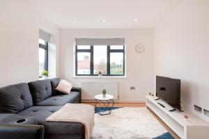 a living room with a couch and a tv at Elegant Living in Coulsdon: One Bedroom Apartment in Coulsdon