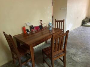 ナングウィにあるVillage Hostelの椅子2脚付きの部屋の木製テーブル