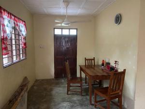 ナングウィにあるVillage Hostelのダイニングルーム(テーブル、椅子、ドア付)