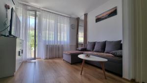 普利特維采湖的住宿－Apartman Filipčić，客厅配有沙发和桌子