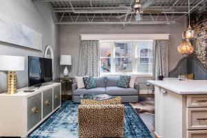 a living room with a couch and a tv at 80 Lex 203 Eclectic Industrial Apt in Asheville