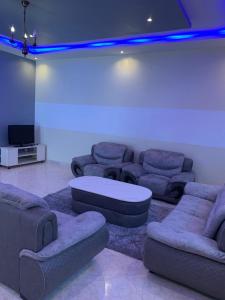 uma sala de estar com sofás, uma mesa e uma televisão em Villa Fama em Mbour