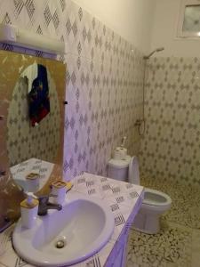 La salle de bains est pourvue d'un lavabo et de toilettes. dans l'établissement Villa Fama, à Mbour