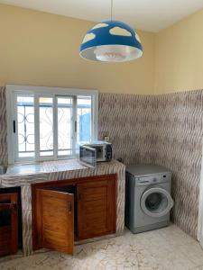 a kitchen with a washing machine and a window at Villa Fama in Mbour