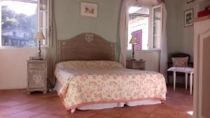 a bedroom with a bed and two windows at B&B L'Avelan in La Trinité