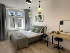 a bedroom with a bed and a desk and two windows at URBAN APARTMENTS PREMIUM No 12A, Free Parking, Self Check-in in Chorzów