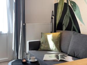 a living room with a couch with a book on a table at URBAN APARTMENTS PREMIUM No 12A, Free Parking, Self Check-in in Chorzów