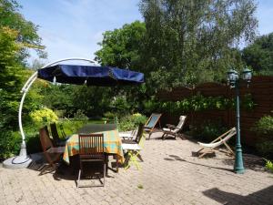 a patio with a table and an umbrella and chairs at Au Relais de Chaussy in Chaussy