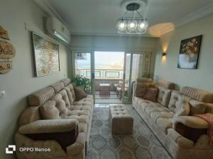 Charming Seaview Condo in Gleem في الإسكندرية: غرفة معيشة كبيرة مع كنب في غرفة