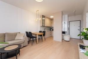 ein Wohnzimmer und eine Küche mit einem Sofa und einem Tisch in der Unterkunft Doki - Luxury Voyager by Grand Apartments in Danzig