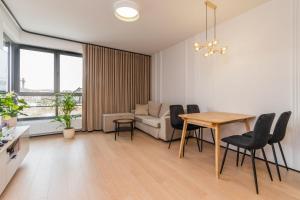 ein Wohnzimmer mit einem Tisch, Stühlen und einem Sofa in der Unterkunft Doki - Luxury Voyager by Grand Apartments in Danzig