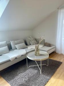a living room with a white couch with a table at Ferienwohnung Huimelig im Allgäu in Röthenbach