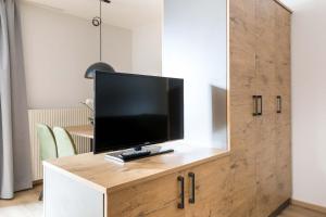 a flat screen tv on top of a wooden cabinet at Landhaus Bergland in Obsteig