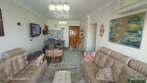 a living room with two couches and a table at Charming Seaview Condo in Gleem G10 in Alexandria