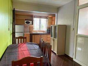 a kitchen with a table and chairs and a refrigerator at Résidence De Tourisme Villa Bougainville in Pereybere