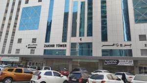 ein Parkplatz vor einem Kathz-Turm in der Unterkunft Loaloat El Sharjah for women in Schardscha