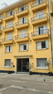 un edificio amarillo con balcones en una calle en La Caravelle en Aix-en-Provence