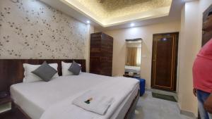 ein Schlafzimmer mit einem großen weißen Bett in einem Zimmer in der Unterkunft Hotel Aradhya Puri Sea View Room - Luxury Stay - Best Hotel in Puri in Puri