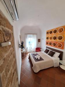 um quarto com uma cama grande e uma parede de tijolos em b&b antichi colori em Cinisi