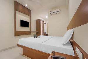 a bedroom with a bed with a sink and a mirror at Collection O Gandhipuram in Coimbatore