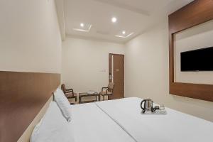 a hotel room with a bed and a tv at Collection O Gandhipuram in Coimbatore