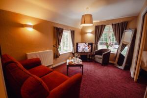 a living room with a couch and a chair at Howfield Manor Hotel in Canterbury