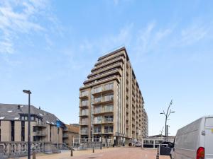 a tall building on a city street with a van at Ocean Suites on floor 10 in Blankenberge