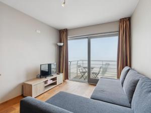 a living room with a couch and a television at Ocean Suites on floor 10 in Blankenberge