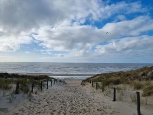 a sandy path leading to the ocean on a beach at Rembrandts beach view in Zandvoort