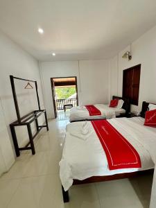 a bedroom with two beds and a desk in it at Residence Boutique Hotel in Luang Prabang